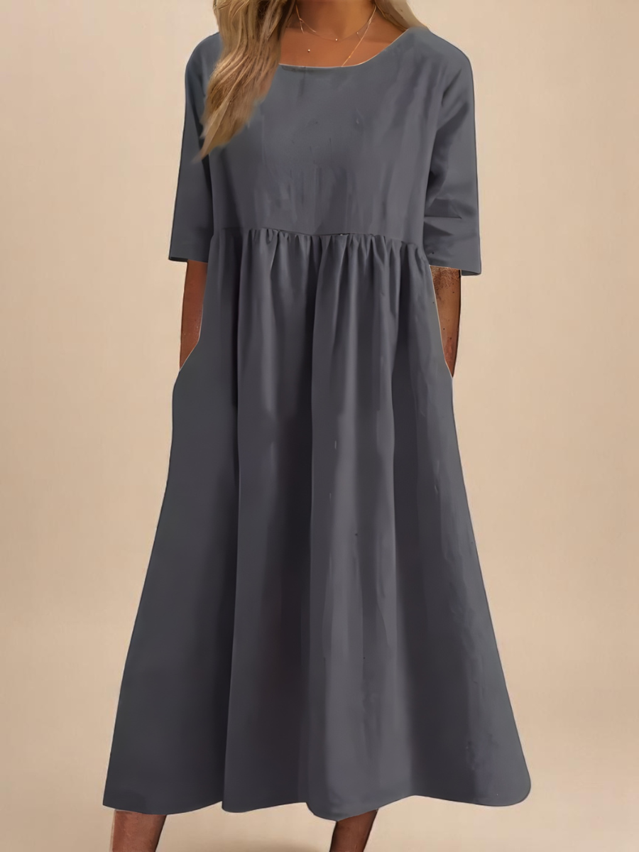Slate grey smock dress featuring gathered waist and flowing skirt
