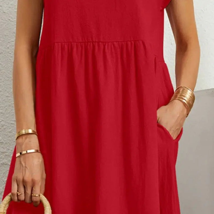 Close-up of red midi dress fabric featuring gathered waist seam and pocket detail