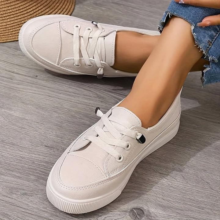 Cream lace-up trainers with flatform sole, styled with frayed denim jeans