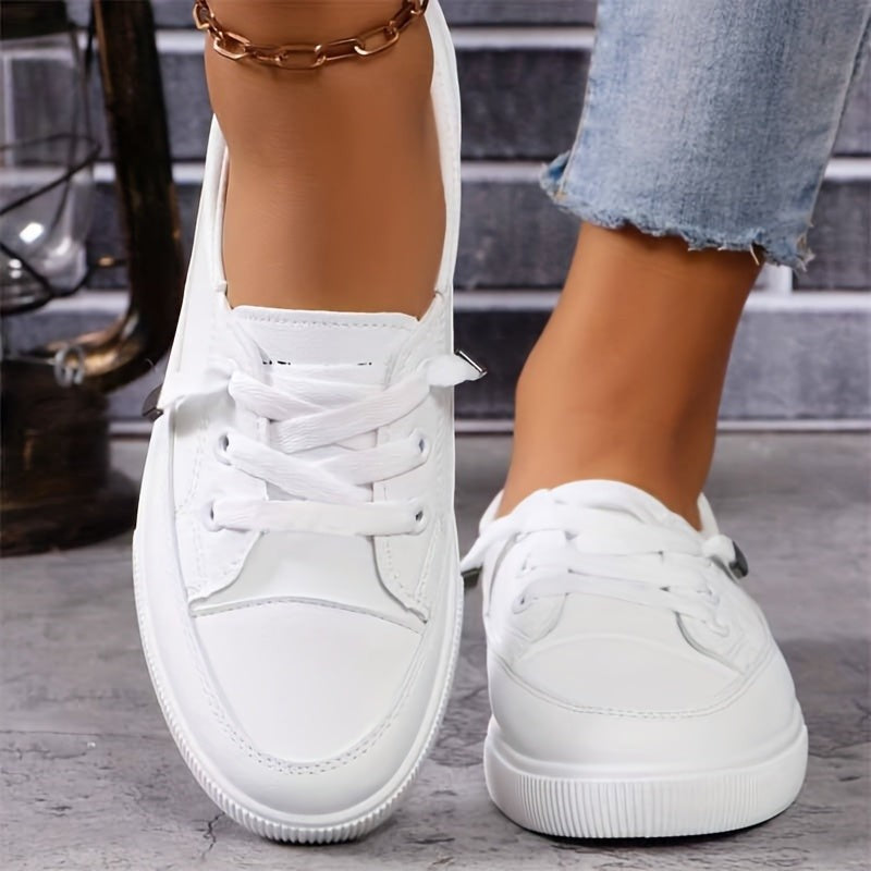 White faux-leather lace-up trainers styled with cropped denim jeans