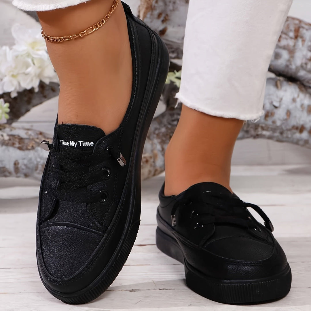 Black lace-up trainers with chunky flatform sole worn with white jeans