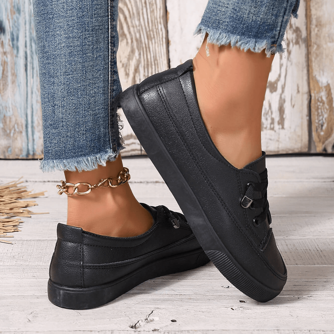 Black leather-look lace-up trainers with anklet, styled with denim jeans