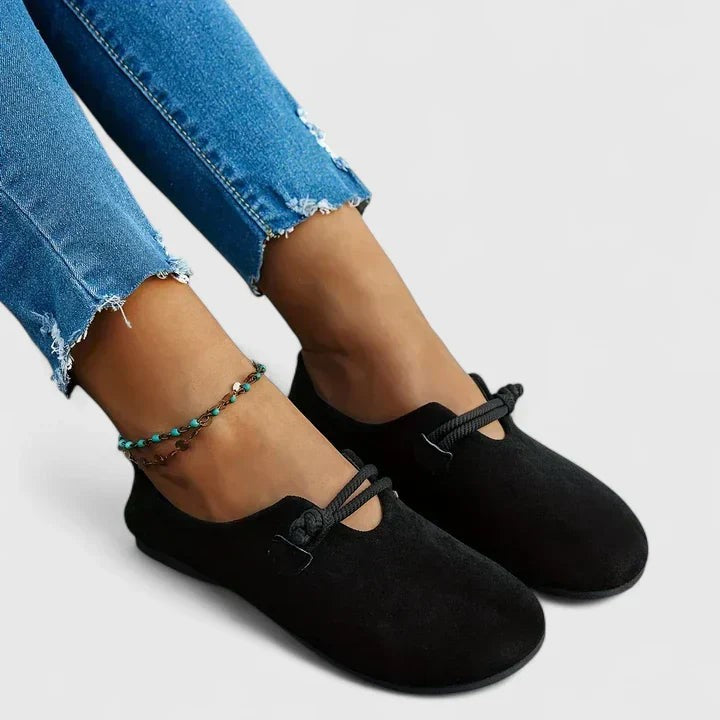 Black suede flat loafers paired with distressed skinny jeans and anklet