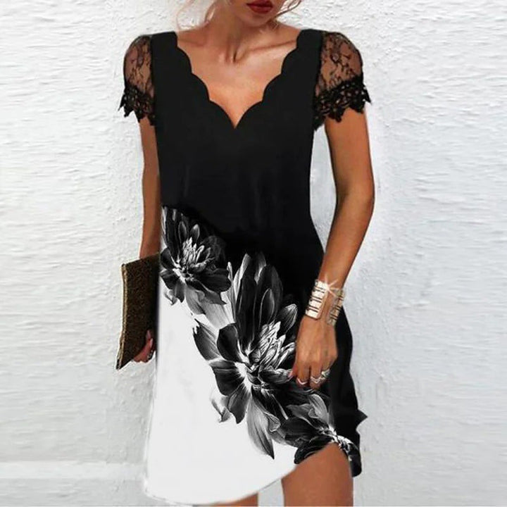 Black mini dress featuring lace sleeves and monochrome floral hem print