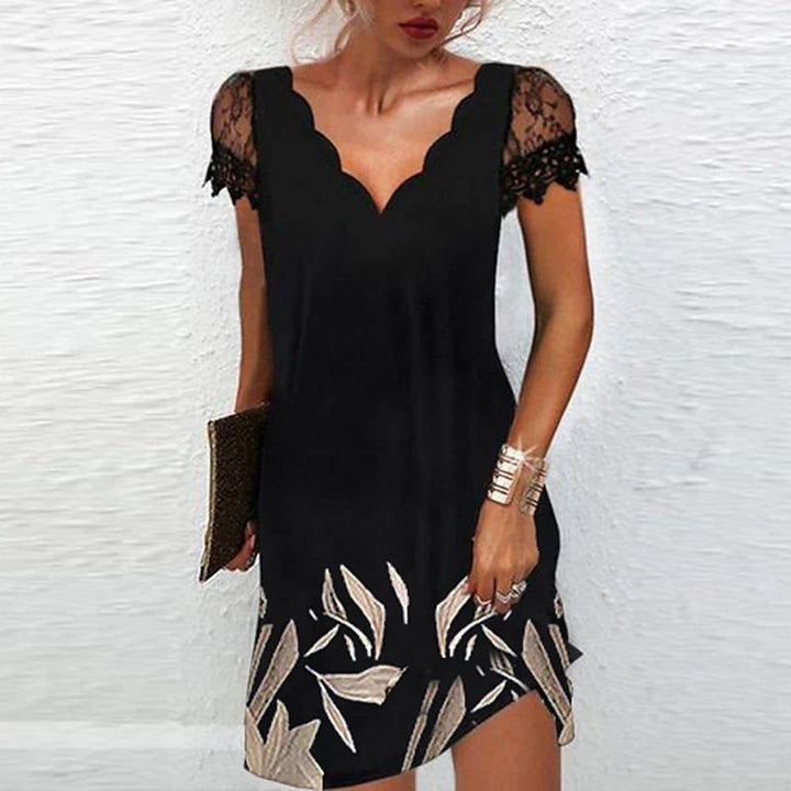 Black lace-trim dress with metallic leaf print detailing at the hem