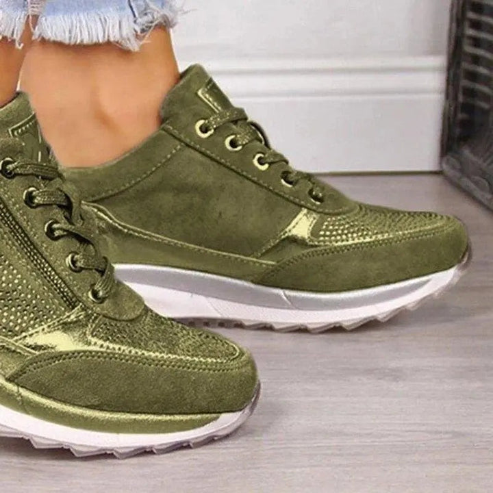 Close-up of khaki suede trainer showing lace-up front and side zip