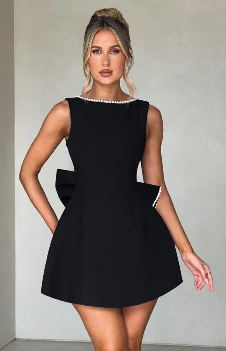 Black sleeveless mini dress with pearl trim and asymmetric bow detail