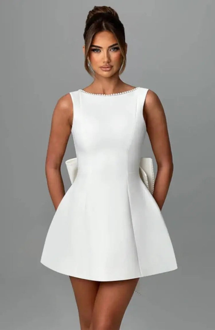 White sleeveless skater dress with pearl beaded neckline and bow