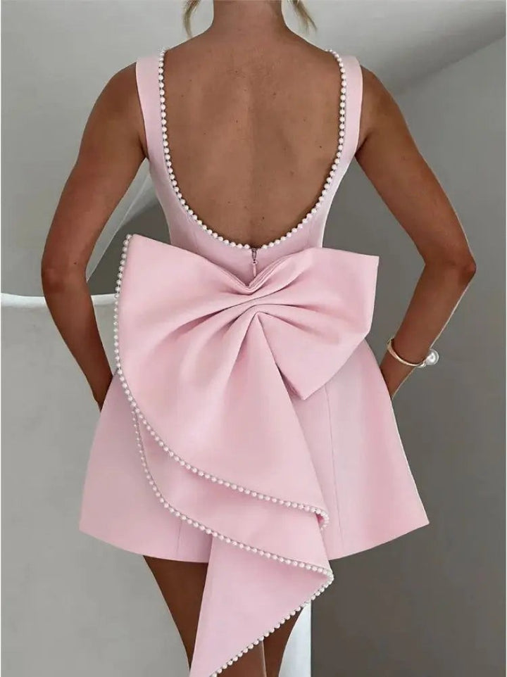 Rear view of pink cocktail dress with layered bow and pearl edging