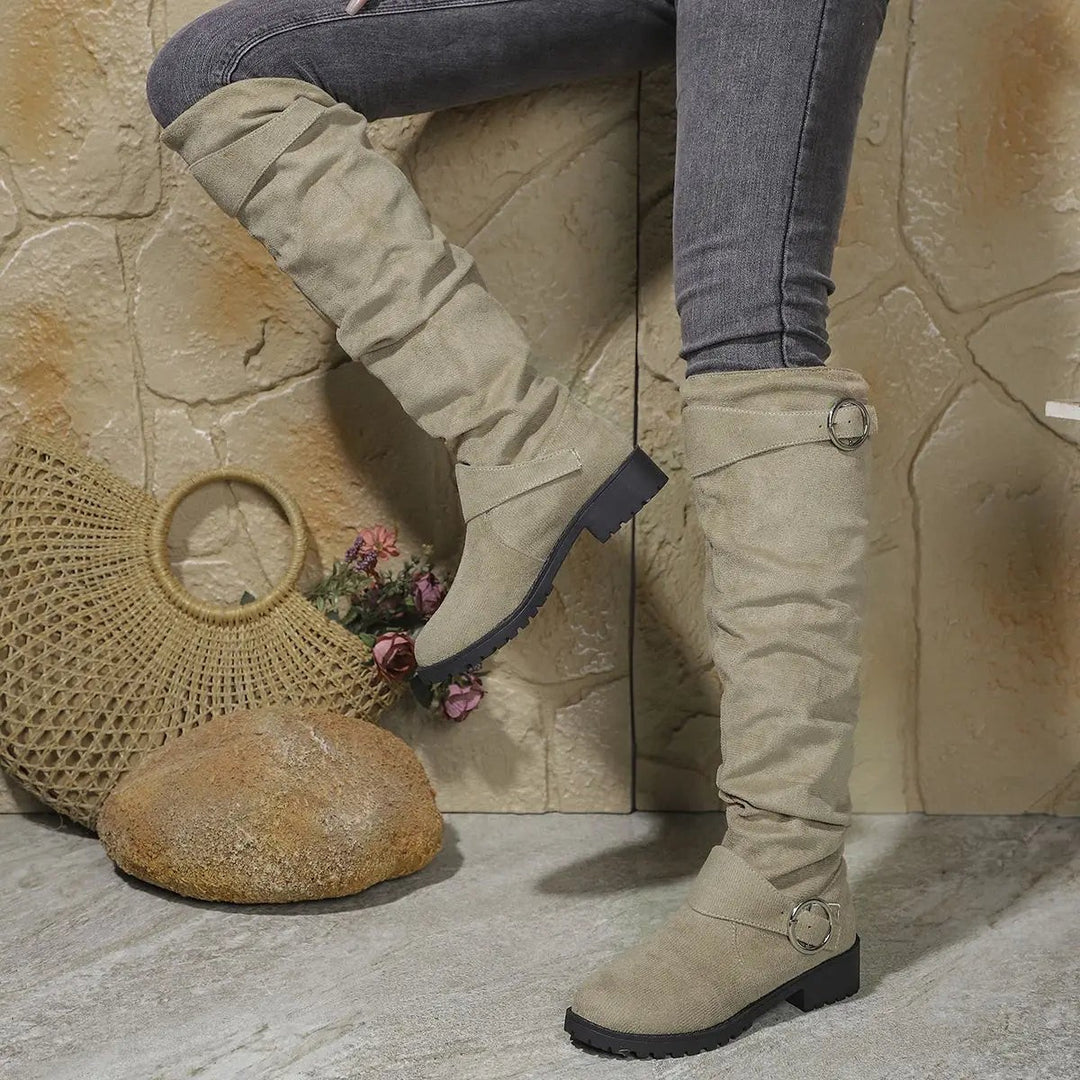 Beige slouchy knee-high boots with buckle strap and low block heel