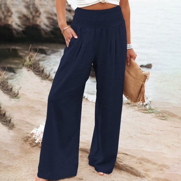 Navy blue wide-leg trousers with smocked elastic waist, beachside styling