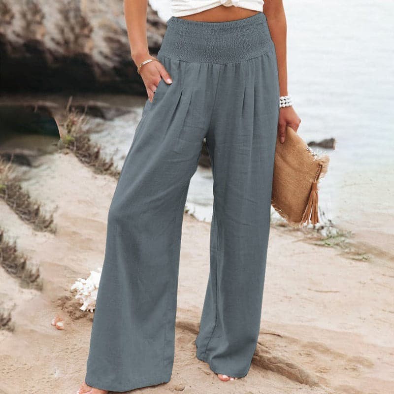 Slate grey wide-leg trousers featuring smocked high waistband and side pockets