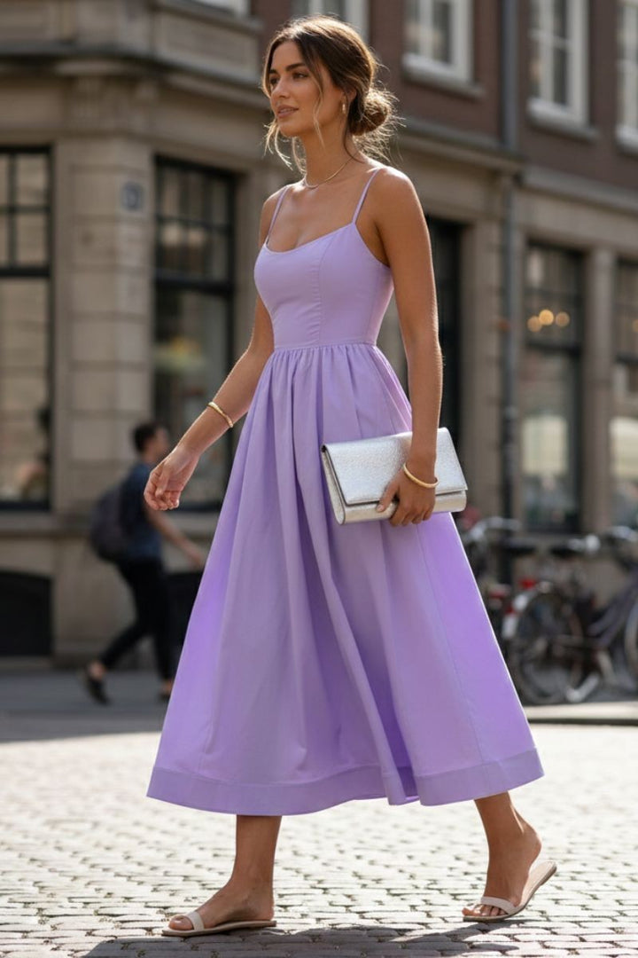 Lilac sleeveless midi dress with fitted waist worn on a cobbled street