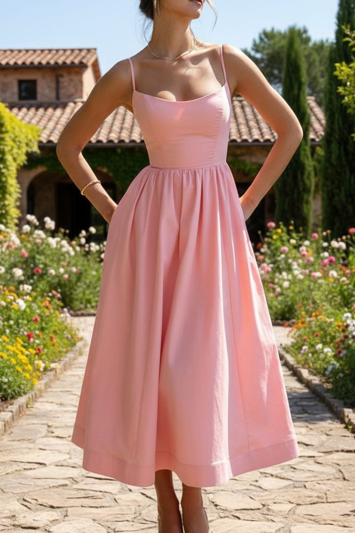 Pink sleeveless midi dress with scoop neck and full skirt in a garden setting