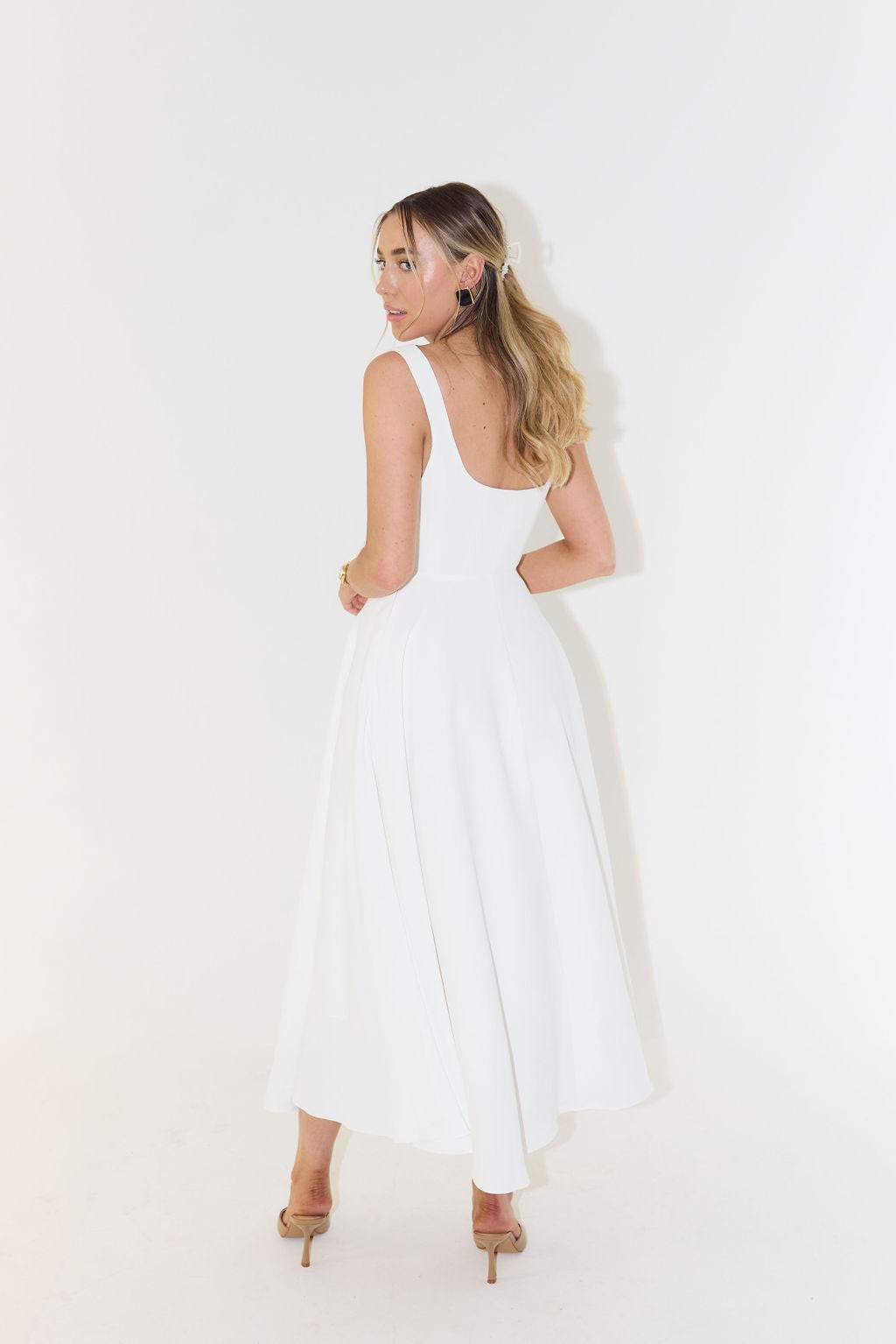 Rear view of white A-line maxi dress highlighting scoop back and swishy hemline
