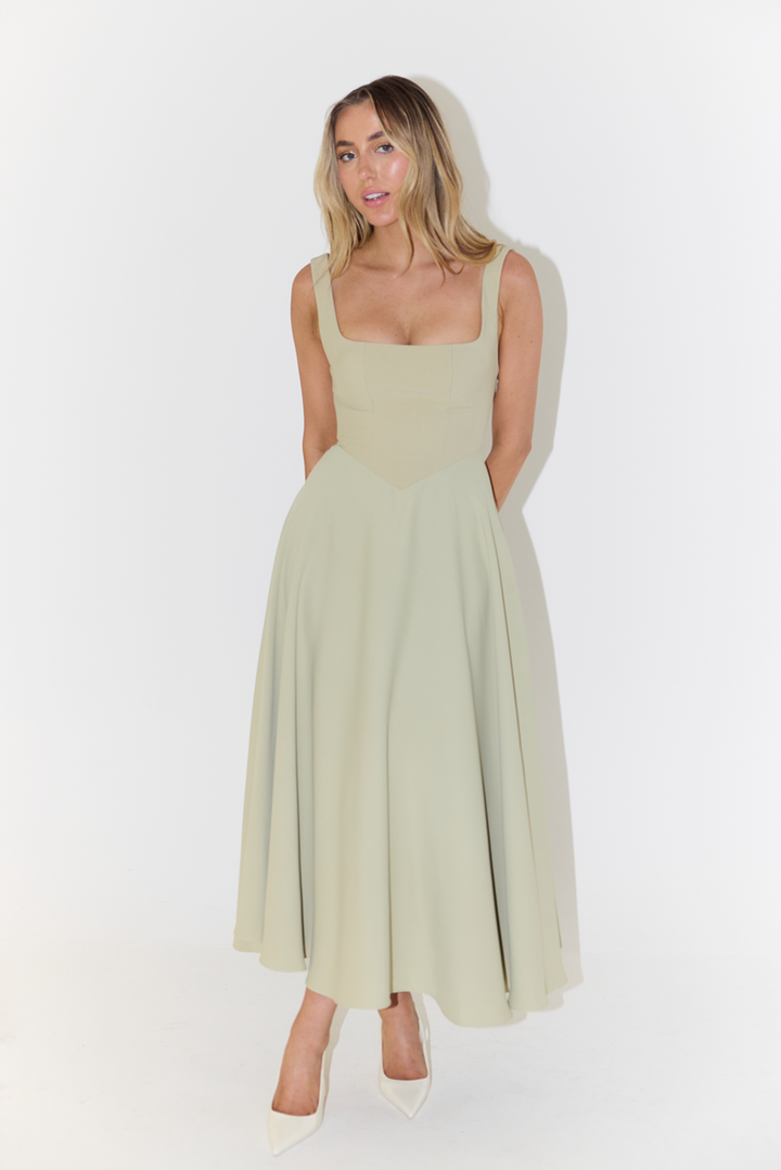 Sage green sleeveless A-line maxi dress with fitted bodice and pointed pumps