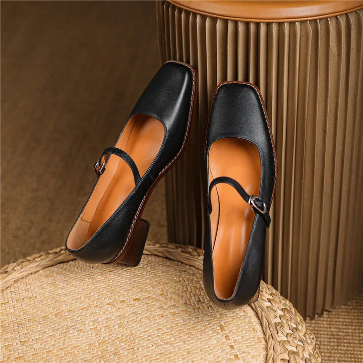Pair of black leather Mary Jane shoes with buckled straps and contrast stitching