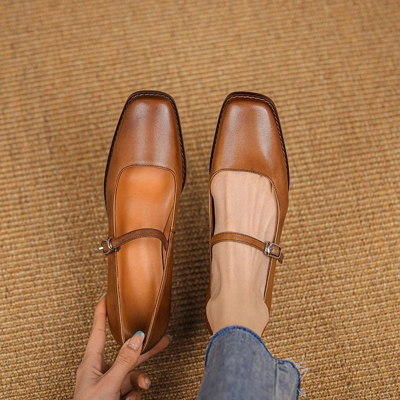 Top-down view of tan leather Mary Jane shoes with buckled straps and stitched trim