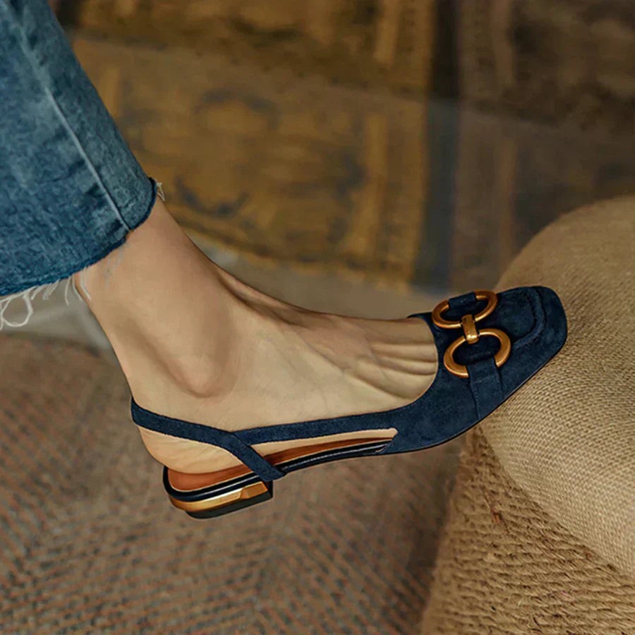Close-up of navy suede orthopedic slingback with gold chain trim detail