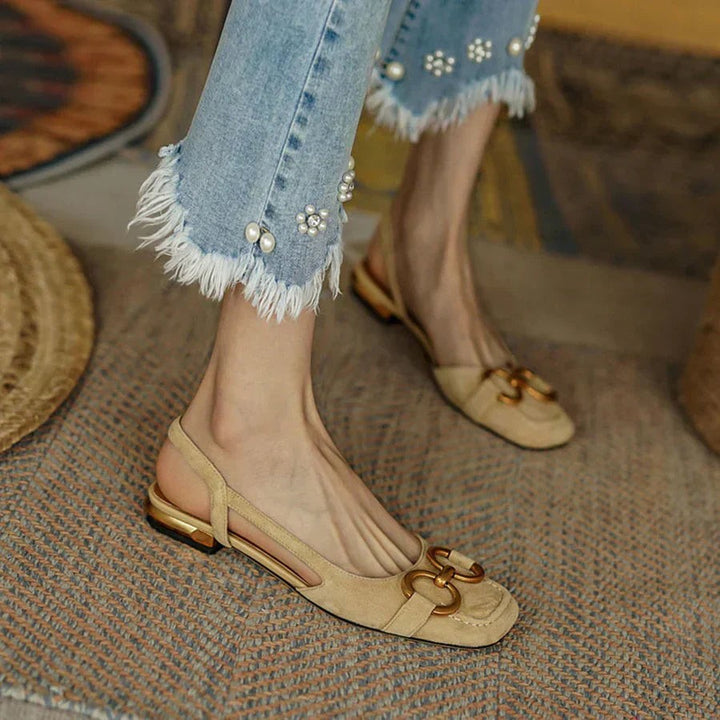 Beige suede slingback sandals with cut-out sides and gold chain accent