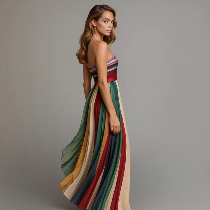 Side profile of multicolour pleated maxi dress highlighting flared silhouette and rich stripe palette