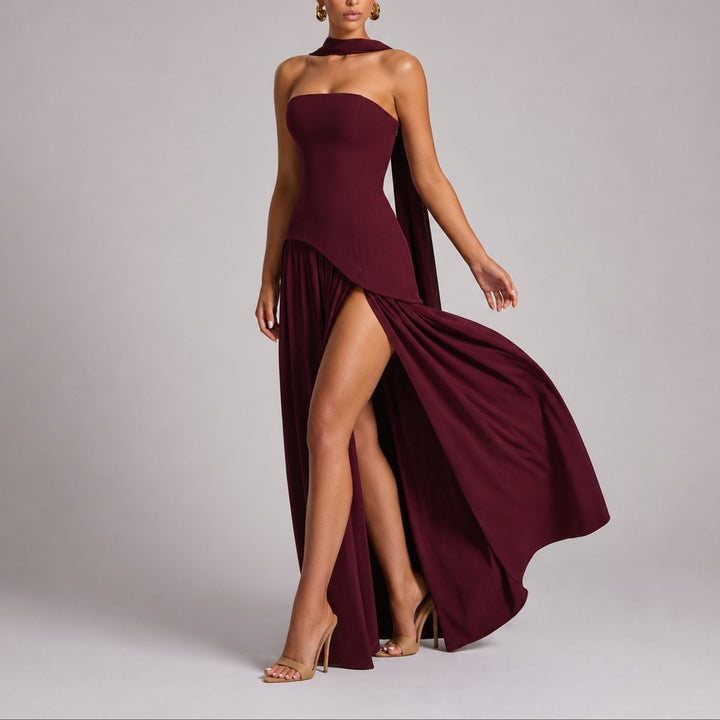 Burgundy strapless gown with flowing cape sleeve and daring leg split