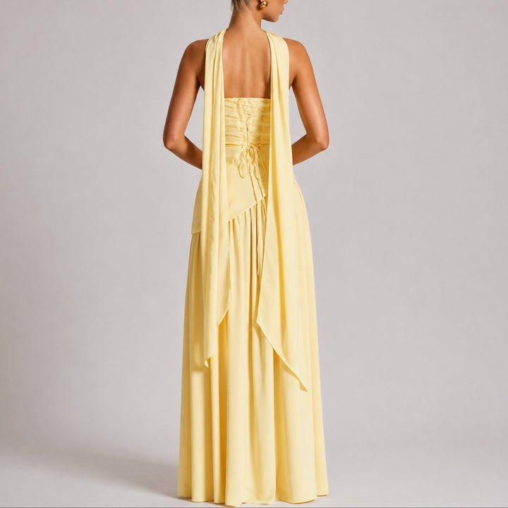 Rear view of pale yellow maxi dress showing lace-up back and draped scarf