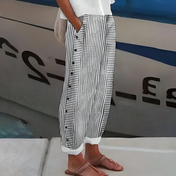 Black and white striped wide-leg trousers featuring decorative button placket