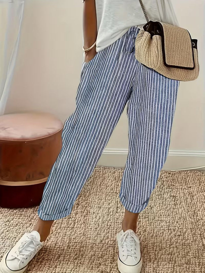 Blue striped wide-leg trousers with turn-up cuffs styled with white trainers