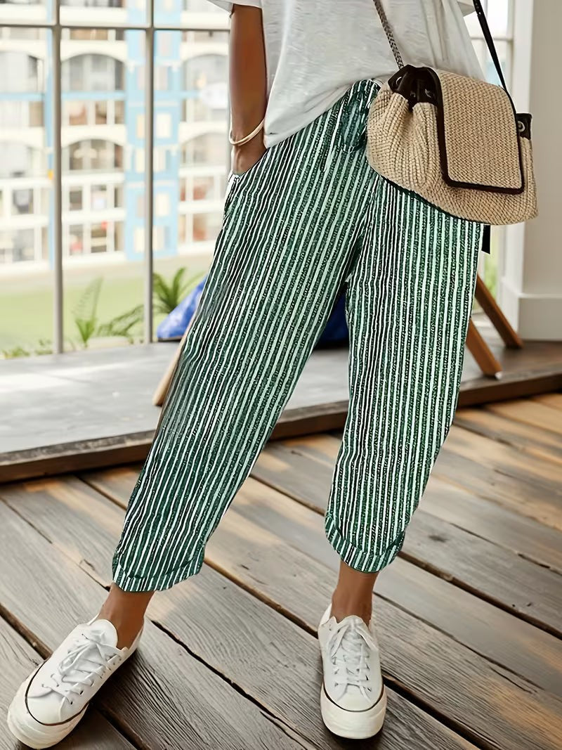 Green striped wide-leg trousers with cuffed hems worn with white trainers