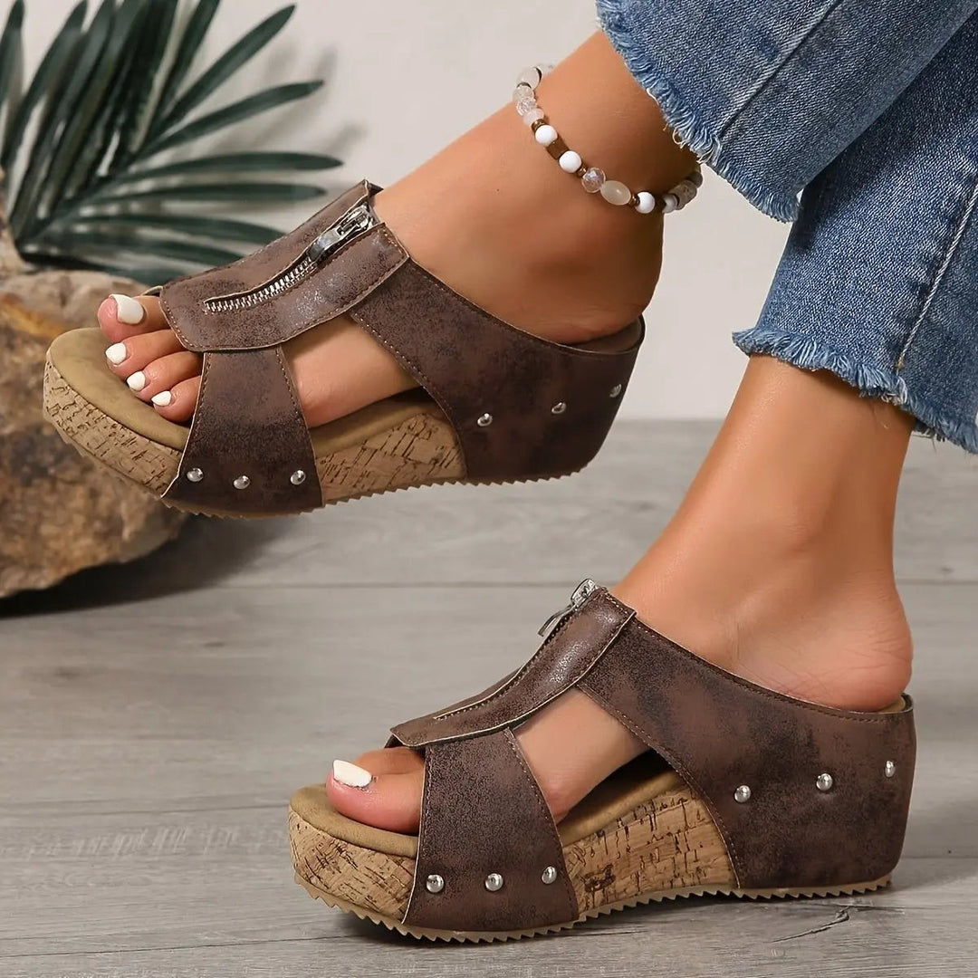 Black cork wedge sandal with silver stud detailing, shown on model's foot
