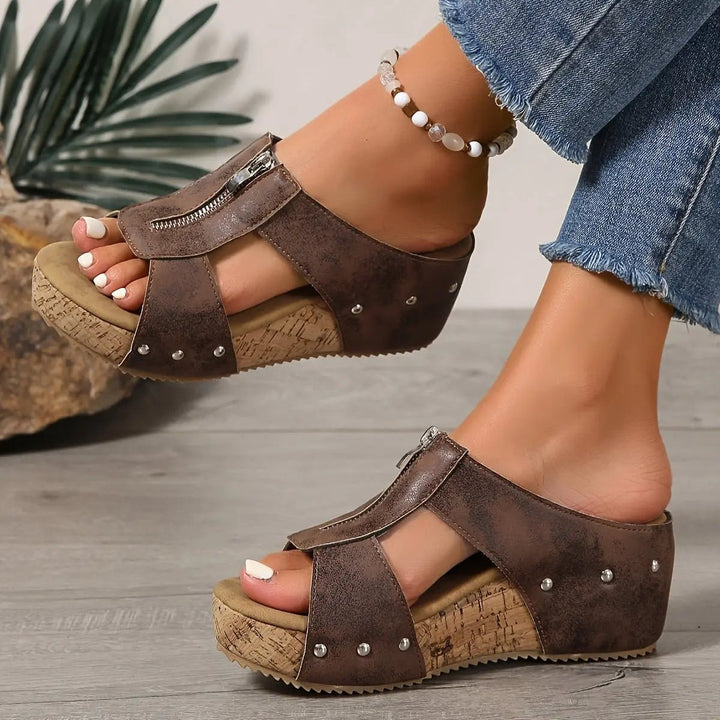 Black cork wedge sandal with silver stud detailing, shown on model's foot