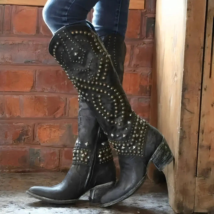 Black leather knee-high western boots with studded swirl detailing and block heel