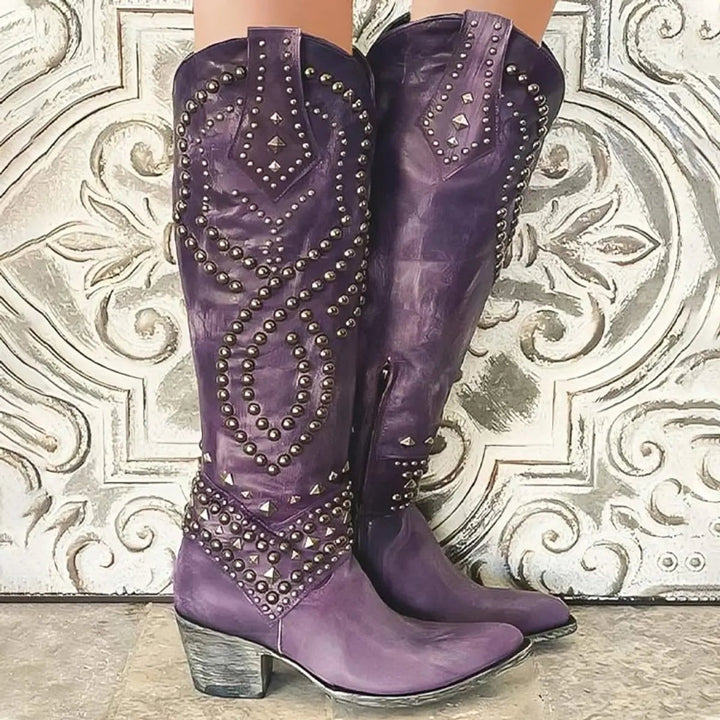 Purple leather knee-high cowboy boots featuring studded pattern and stacked block heel