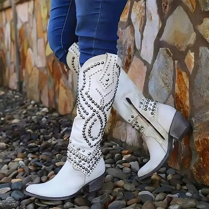 Cream leather knee-high cowboy boots with silver studded swirl design and block heel