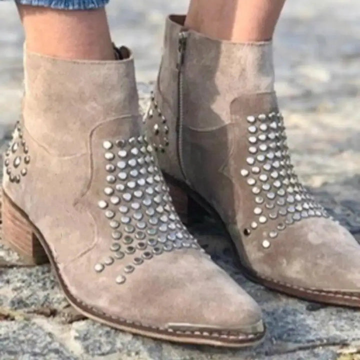 Close-up of studded suede ankle boots featuring side zip fastening