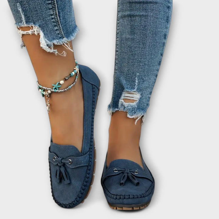 Navy suede tassel loafers shown from above, styled with ripped skinny jeans