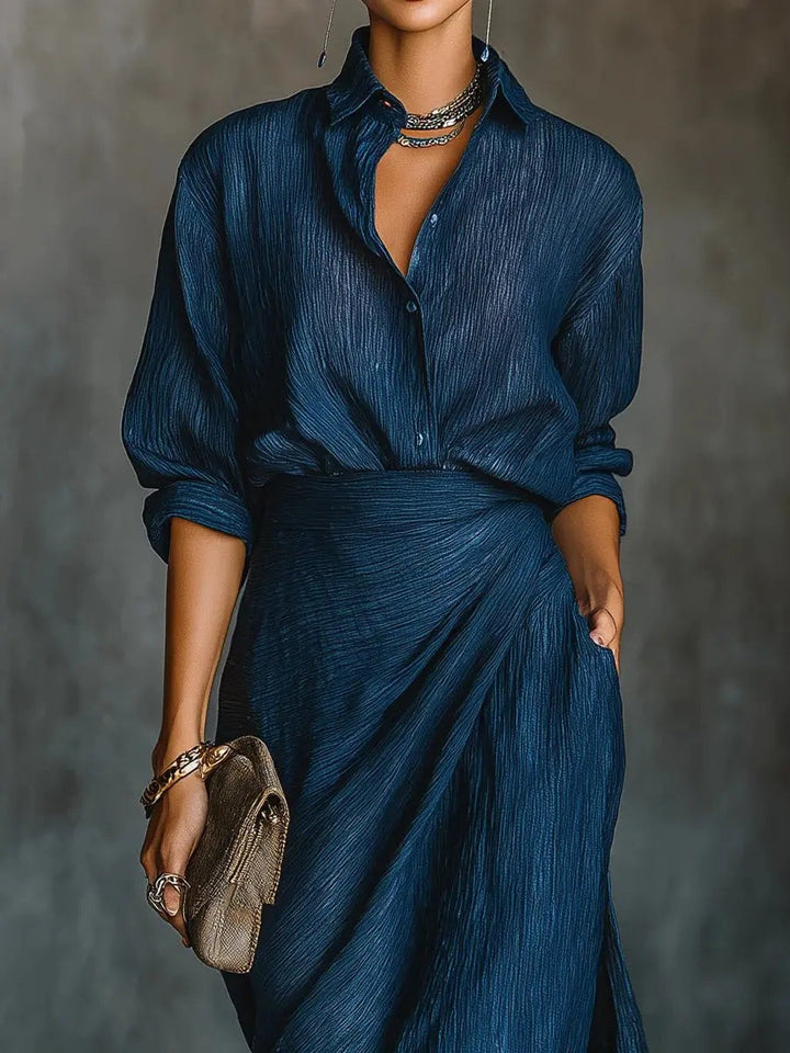 Close-up of navy button-front shirt dress showing crinkled texture and collared neckline