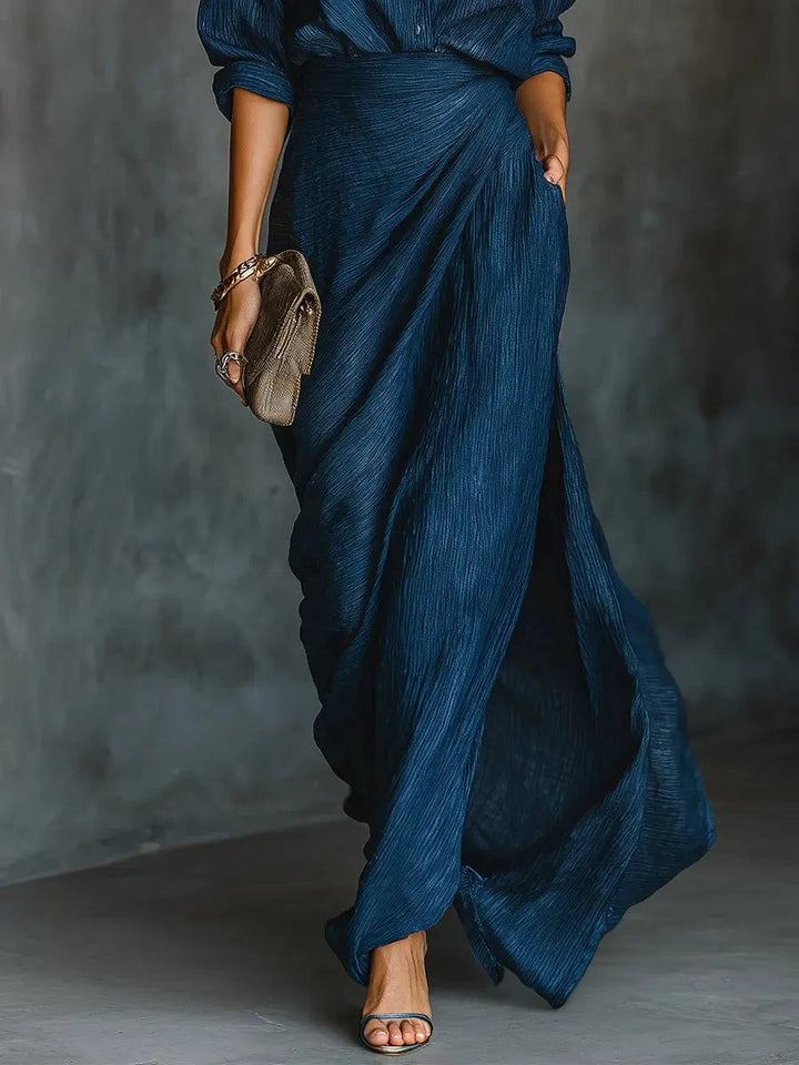 Draped navy maxi skirt with thigh-high split, shown with strappy heeled sandals