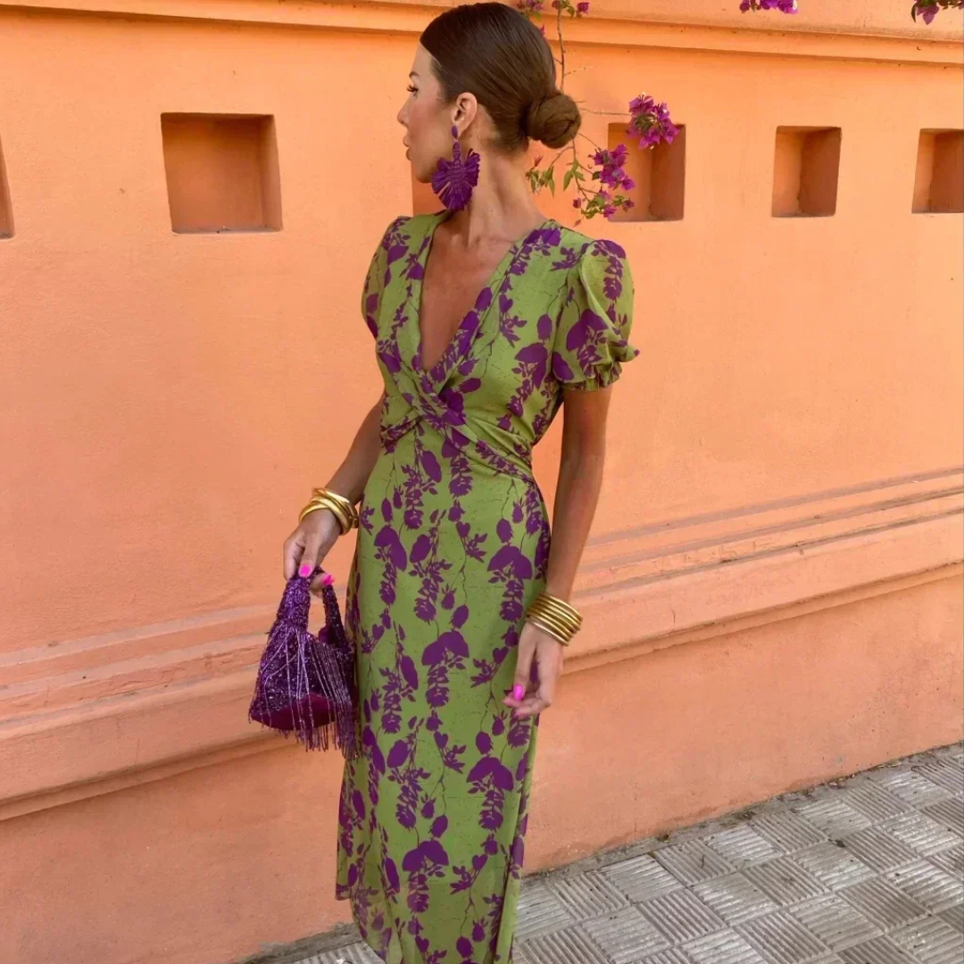 V-neck wrap maxi dress in green with purple leaf print, styled with tassel bag