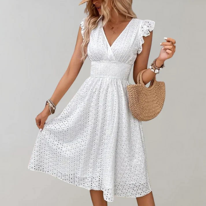 White broderie anglaise midi dress with flutter sleeves and cinched waist, styled with straw handbag