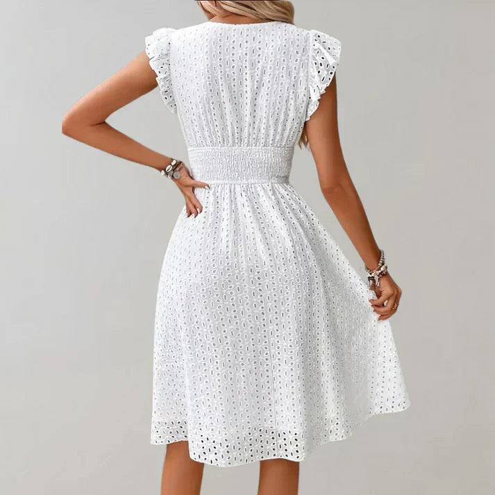 Back view of white midi dress showing smocked waist and ruffled shoulder detailing