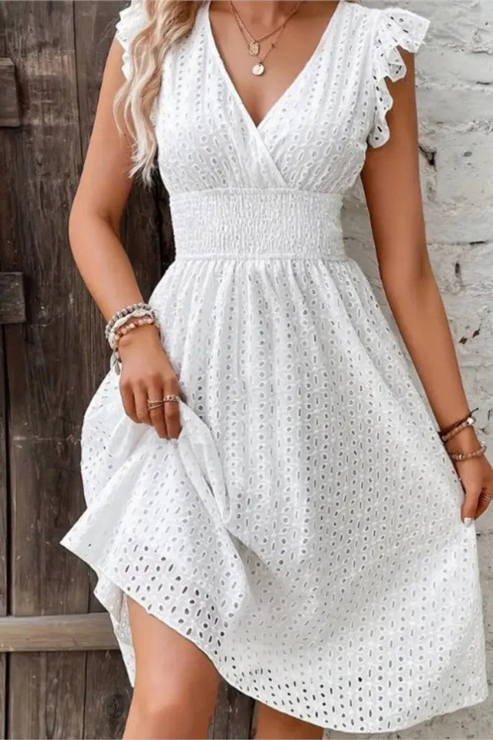 White broderie anglaise wrap-style dress with ruffled cap sleeves and cinched waist