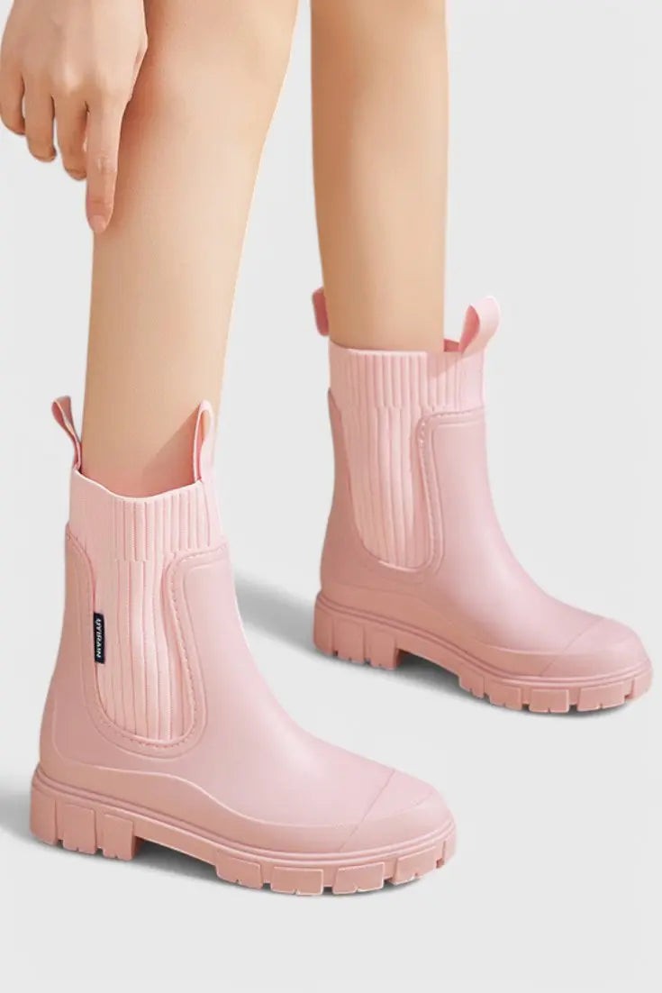Black Chelsea rain boots worn on model, walking pose close-up