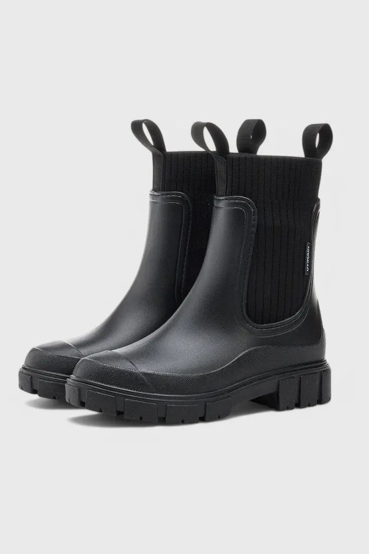 Black waterproof Chelsea boots featuring ribbed sock cuff and lugged sole