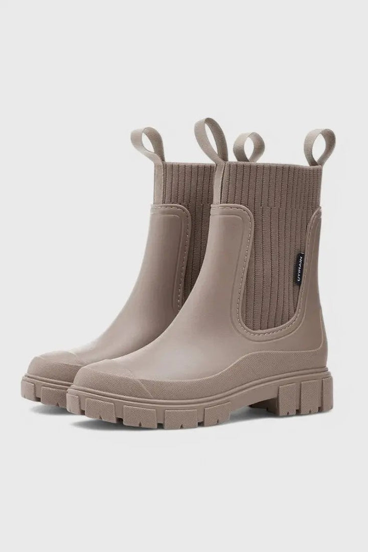 Taupe waterproof Chelsea boots showing ribbed knit panel and lugged sole