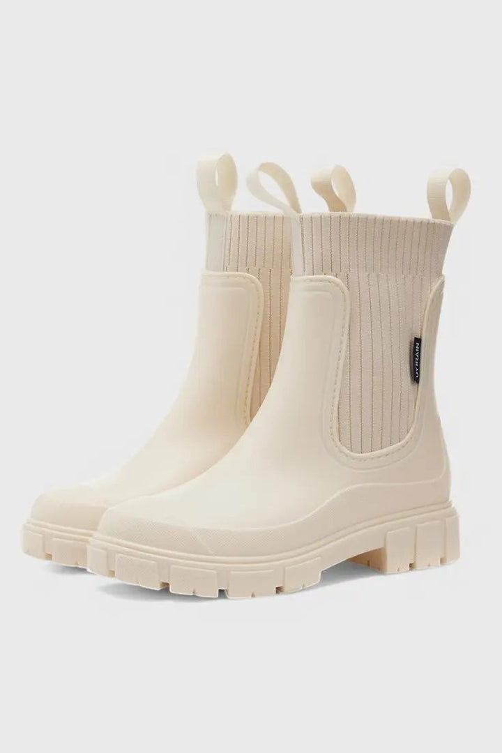 Cream Chelsea rain boots with ribbed knit ankle cuff and chunky sole
