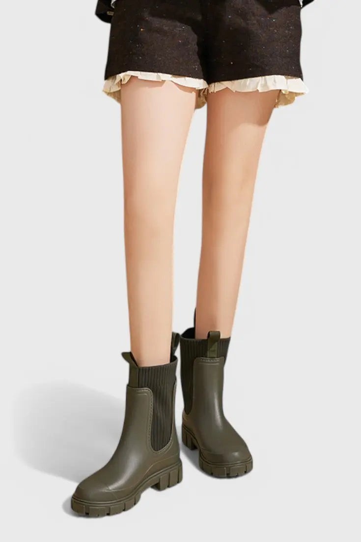 Olive green waterproof ankle boots worn on model, front view