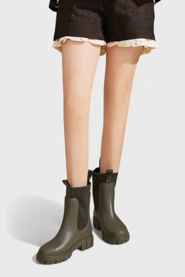 Olive green waterproof ankle boots worn on model, front view