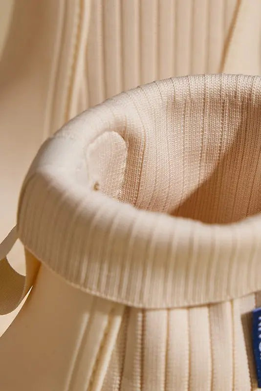 Close-up of ribbed knit cuff and pull-tab on cream Chelsea rain boot